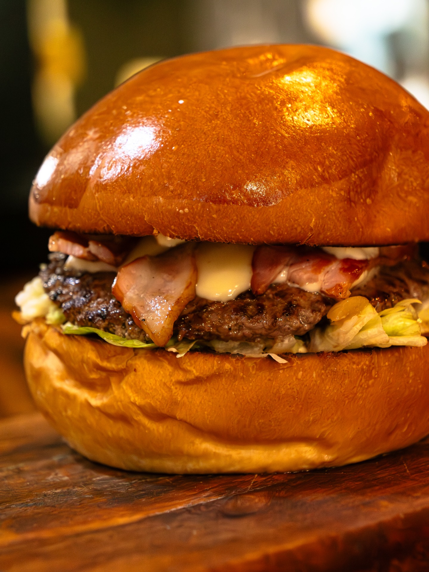 Le MONTAGNARD (Pain brioché, steak de boeuf du boucher, fromage à raclette, poitrine grillée, confit d'oignons, sauce au choix)